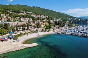 A coastal town with a marina, sandy beach, and residential buildings. - Apartment Darko (Opatija)