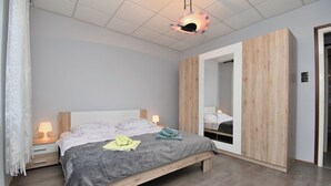 A bedroom with a bed, bedside tables, a wardrobe, and a ceiling light fixture. - Apartment Darko (Opatija)