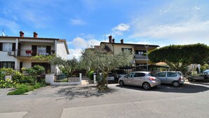 A residential street with two-story houses, a gated entrance, and parked cars. - Apartment Elizabeta (Umag)
