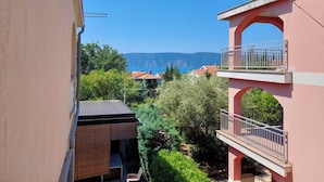 A residential building with a balcony overlooking a coastal view. - Apartments Baburic (Krk)