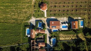 Une vue aérienne d’une propriété comprenant des bâtiments numérotés, une piscine et un grand terrain.