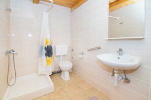 Ein Badezimmer mit Dusche, Toilette und Waschbecken.