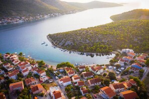 An aerial view of a coastal village with houses, a marina, and a bay. - Apartment Niko (Sibenik)