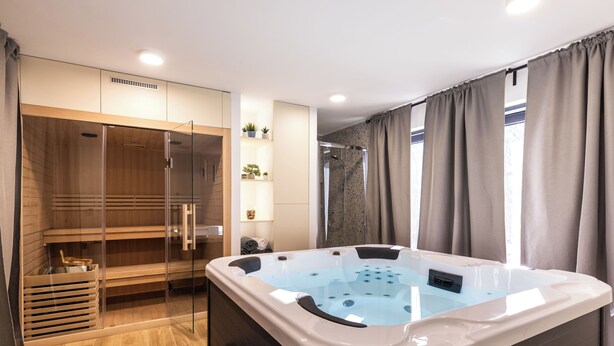 A modern bathroom with a glass-enclosed shower, a freestanding bathtub, and a wooden vanity. - House Medvjed (Ravna Gora)