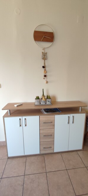A kitchen with a wooden countertop, white cabinets, and a wall-mounted clock. - Apartment Meri (Lopar)