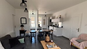 Un salon moderne comprenant un canapé, une table basse et un coin repas avec des chaises et une table.