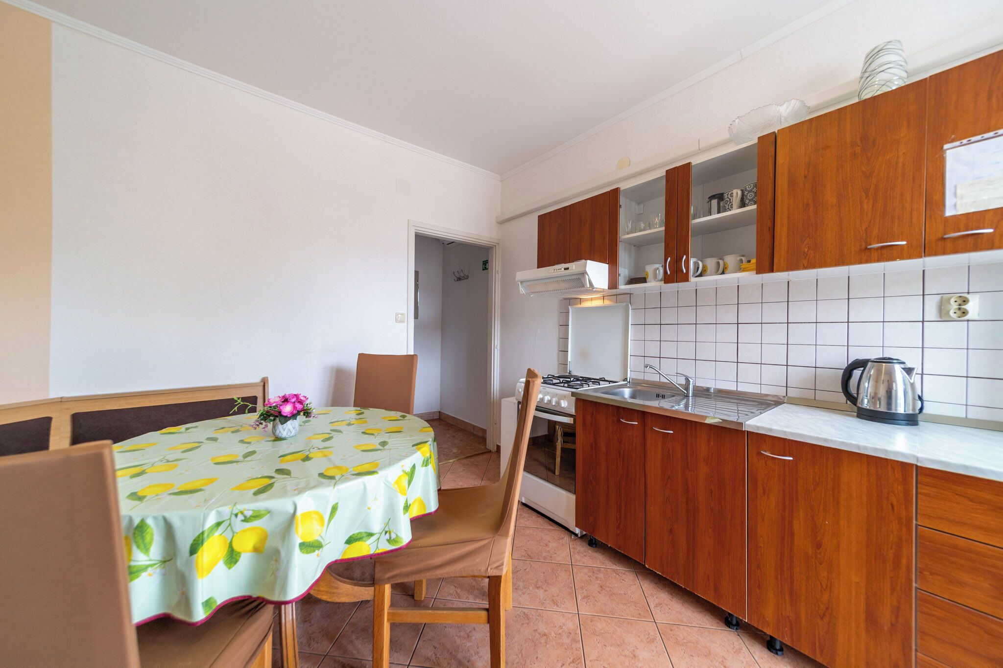 A kitchen with wooden cabinets, a stove, and a sink.