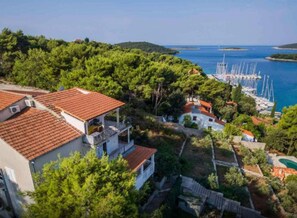 A coastal property with a view of the sea, a marina, and lush greenery. - Apartments Vesna (Solta)
