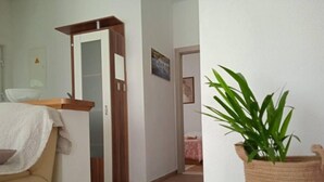 A room with a wooden door, a potted plant, and a beige sofa. - House Garden House (Kastela)