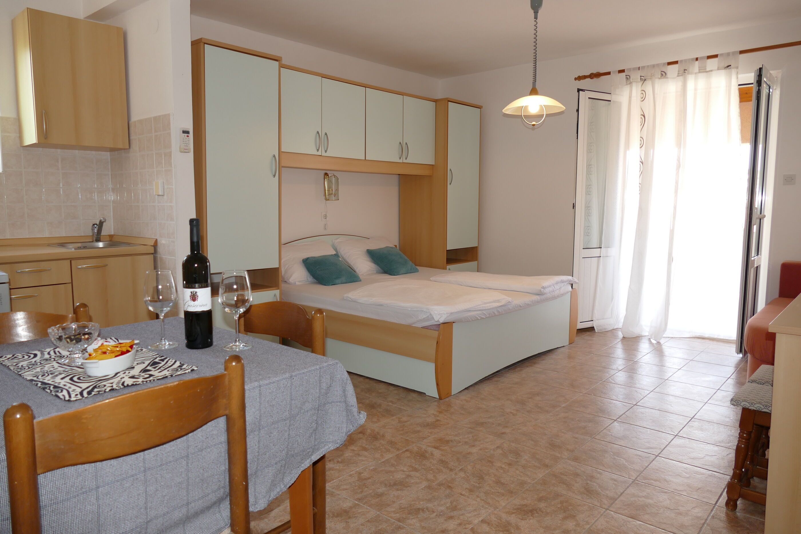 Una stanza compatta con un letto, un angolo cottura e una zona pranzo.