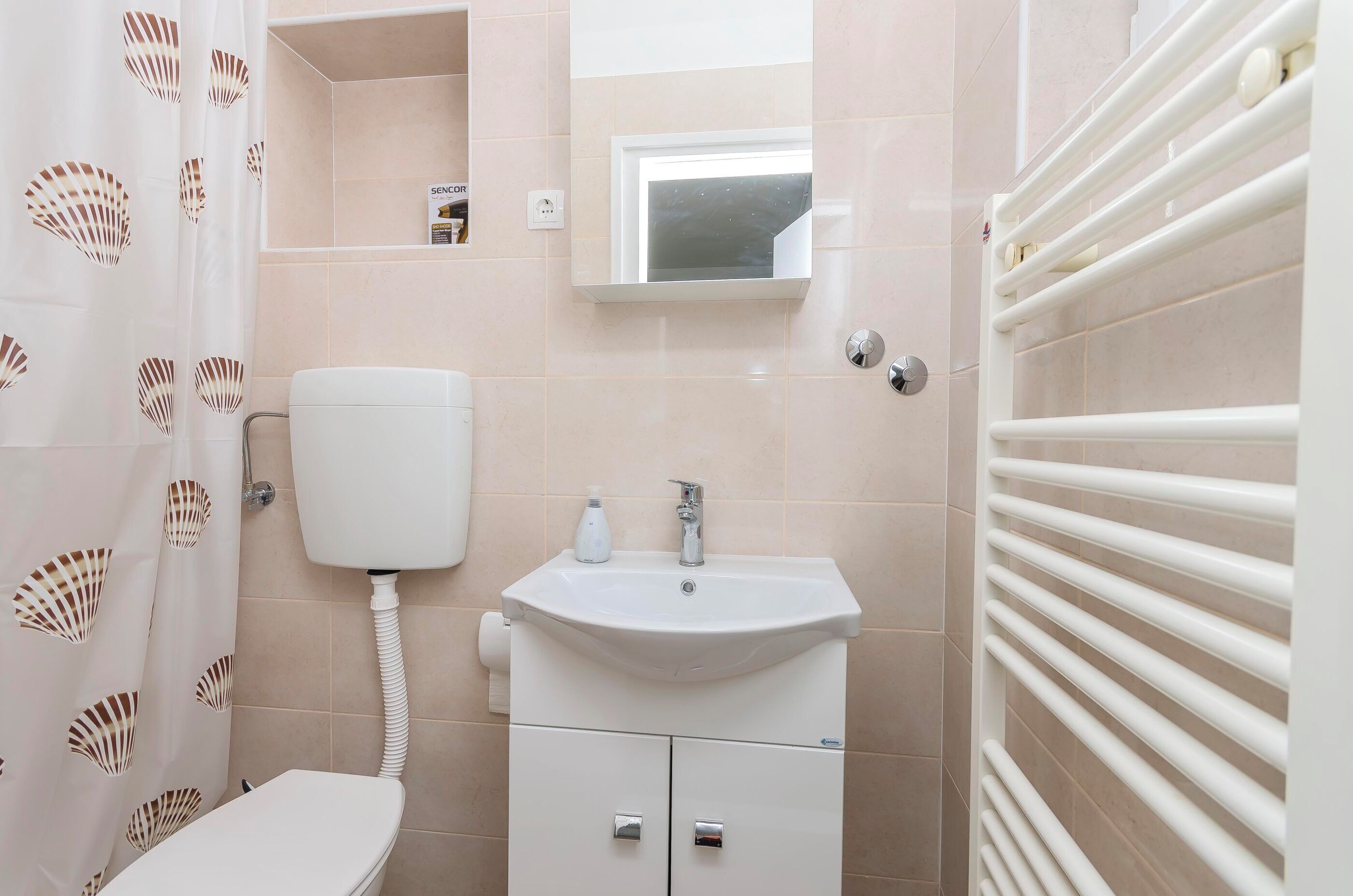 A bathroom with a toilet, sink, and towel rack.