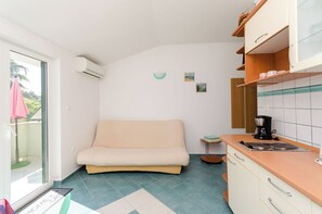 A compact kitchen with a sofa, a small side table, and a coffee maker. - Apartments Ruzica M (Lopar)