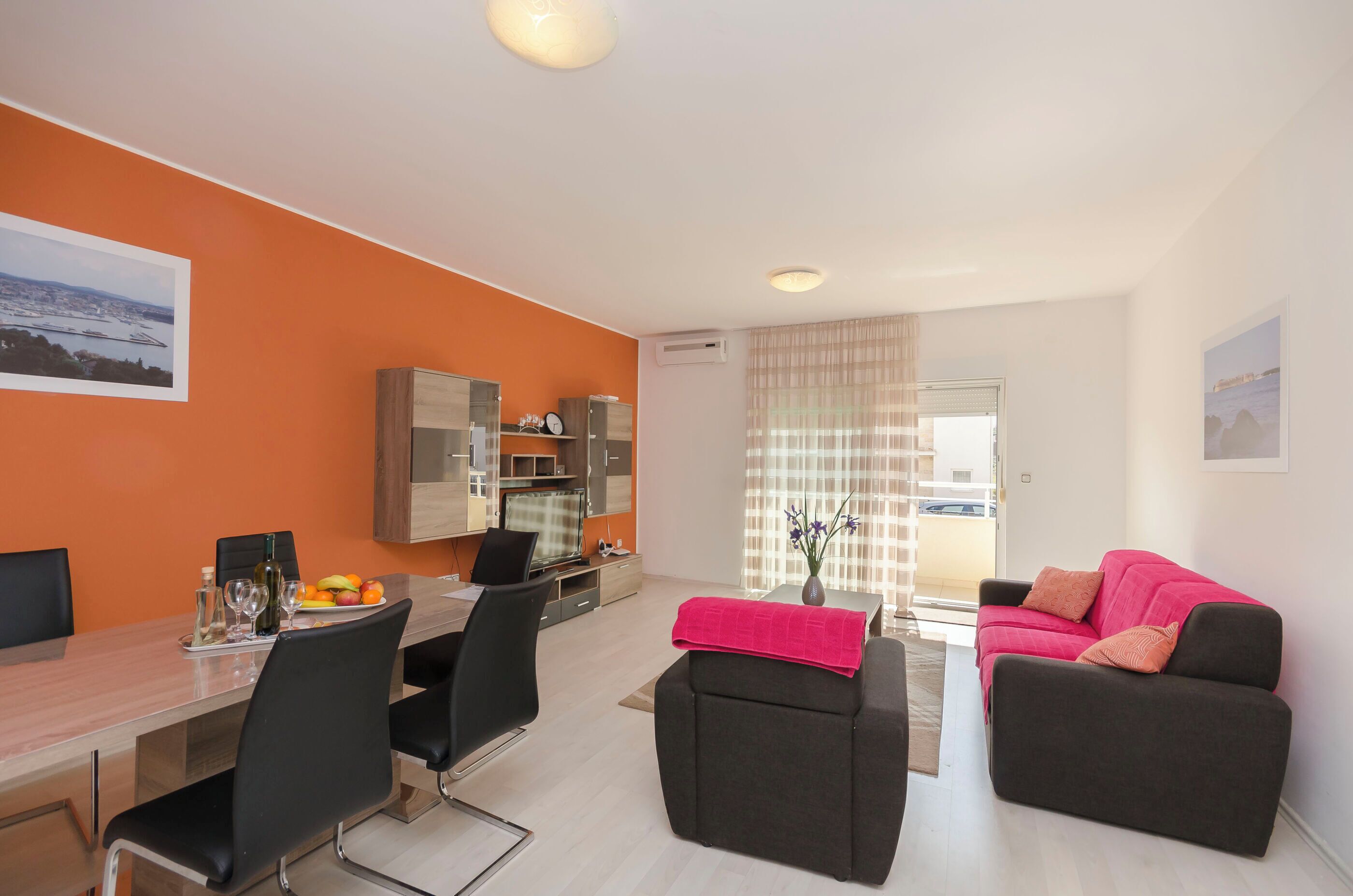 Un salon moderne avec un coin repas, comprenant un canapé, une table basse et un téléviseur.