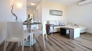 Una sala de estar moderna con comedor, que incluye un sofá, una mesa de centro y una mesa de comedor con sillas.
