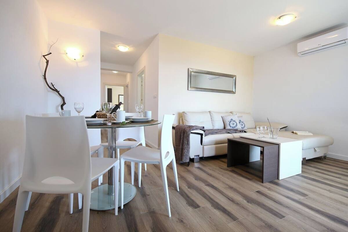 Un salon moderne avec un coin repas, comprenant un canapé, une table basse et une table à manger avec des chaises.