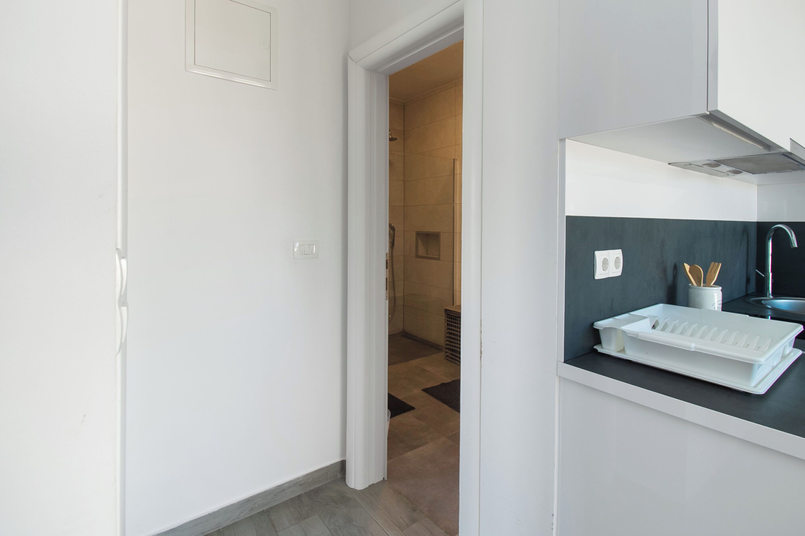 A modern bathroom with a shower, a sink with a tray, and a towel rack.
