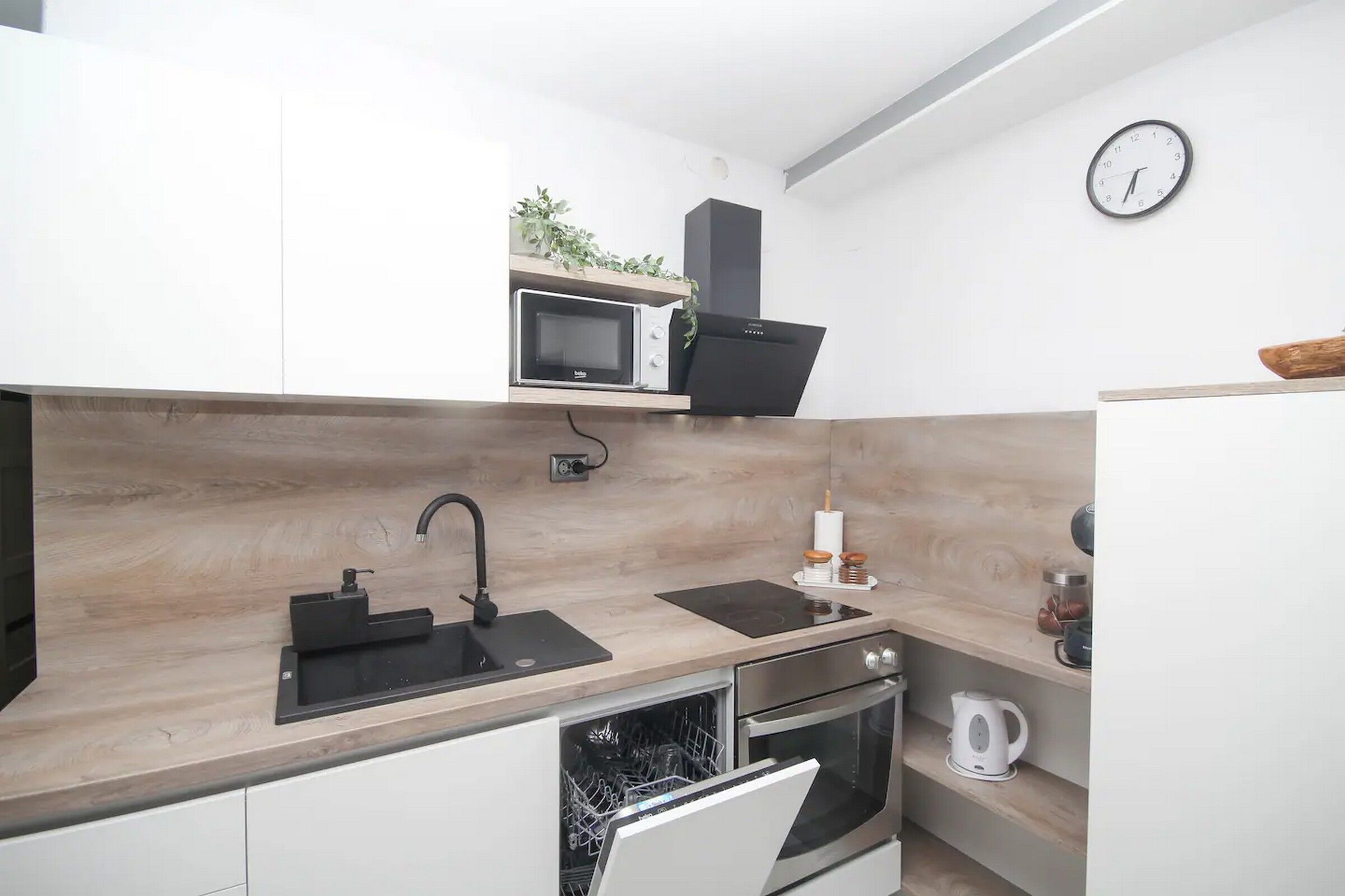 Eine moderne Küche mit Mikrowelle, Backofen und Spüle.