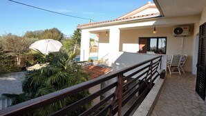 A balcony with a railing, a white umbrella, and a small pool. - Villa Mirka (Barban)