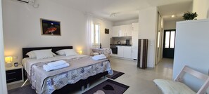A bedroom with a bed, bedside tables, a nightstand, a small table with a bottle, and a chair. - Apartments Pleasures (Jelsa)