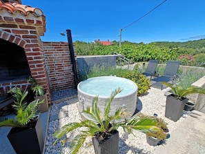 A rooftop patio with a hot tub, outdoor seating, and a brick oven. - House Dawn (Rab)