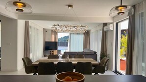 Un comedor moderno con una mesa grande, sillas y una araña.