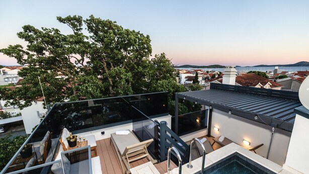 A rooftop terrace with a swimming pool, lounge area, and a view of the city and sea. - Villa Tria Quercus (Vodice)