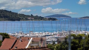 A marina with numerous sailboats docked, surrounded by residential buildings with red-tiled roofs. - Villa Tria Quercus (Vodice)