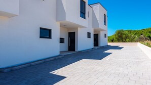 A modern building with a flat roof and a paved courtyard. - Villa Navy Lemon (Vodice)