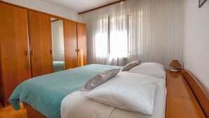 A bedroom with a bed, a wardrobe, and a lamp. - Apartments Jasmine (Biograd na Moru)