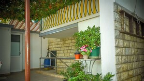 A courtyard with potted plants, a metal railing, and a stone wall. - Apartments Jasmine (Biograd na Moru)