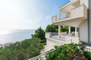 Ein modernes, zweistöckiges Gebäude mit einem Balkon, der auf ein Gewässer blickt.