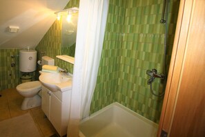 Une salle de bain avec des toilettes, un lavabo et une baignoire.