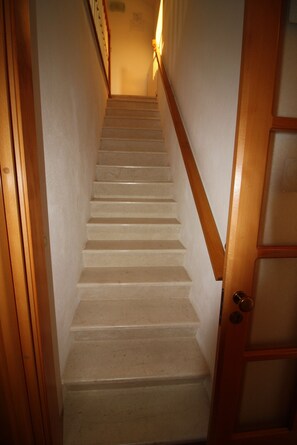 A staircase with wooden handrails and a door with glass panels. - Apartment and Room Lada (Selca)
