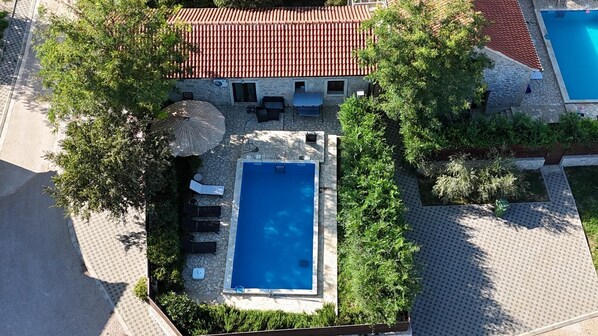 An aerial view of a property with a swimming pool, stone patio, and a red-tiled roof. - House Stone Curlew 2 (Benkovac)