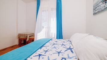 Un dormitorio con cama, una mesita y una silla.
