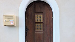 A wooden door with a number plate, a mail slot, and a small mailbox to the left. - Maison Cévenole - Village center - Flexible arrival (Saint-Jean-du-Gard)