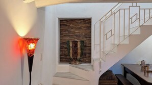 A modern interior with a staircase, a fireplace, a dining table, and a sofa. - Maison Cévenole - Village center - Flexible arrival (Saint-Jean-du-Gard)