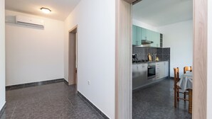 Une cuisine moderne avec des carreaux gris, des appareils en acier inoxydable et des meubles de couleur turquoise.