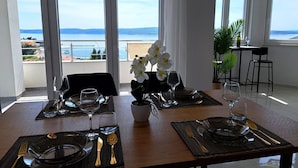A dining table set for two with a view of the sea. - Apartment Beach View (Crikvenica)