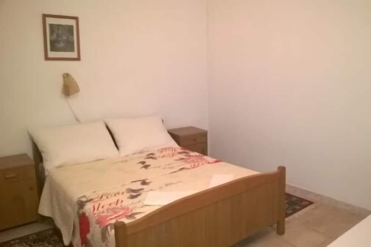 Une chambre à coucher avec un lit en bois, une table de chevet et une commode.