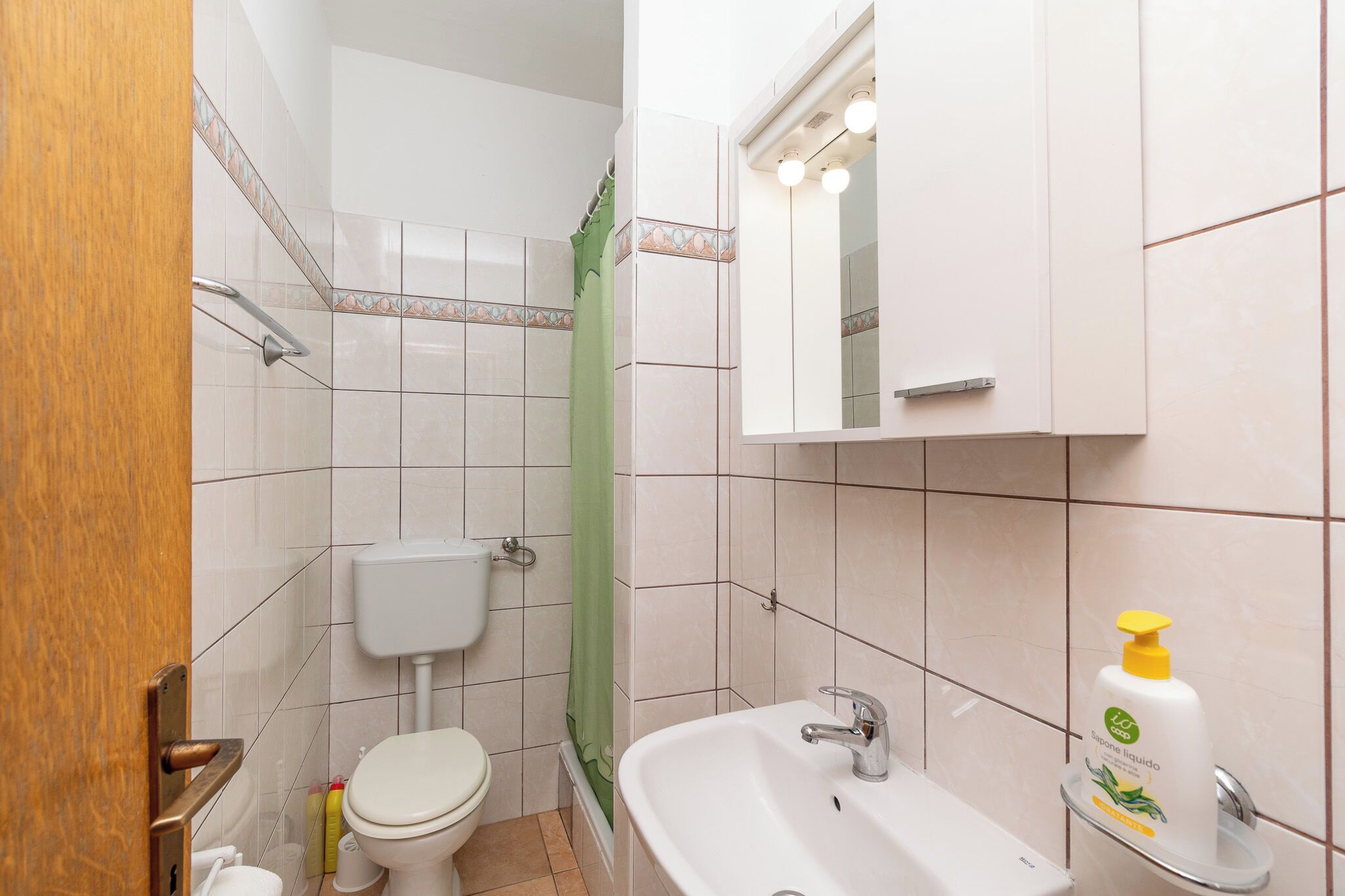 Un baño con inodoro, lavabo y espejo.