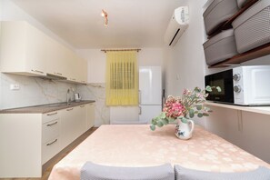 A modern kitchen with a marble countertop, a built-in oven, and a microwave. - Apartments Mirjana (Marina)