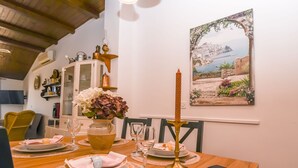 A dining table set with plates, glasses, and a candle. - Apartment Sasa (Kastela)