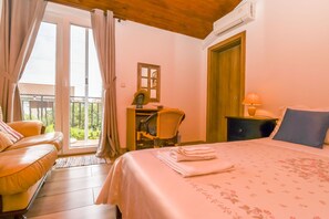 A hotel room with a bed, a desk, a chair, and a balcony. - Apartment Sasa (Kastela)