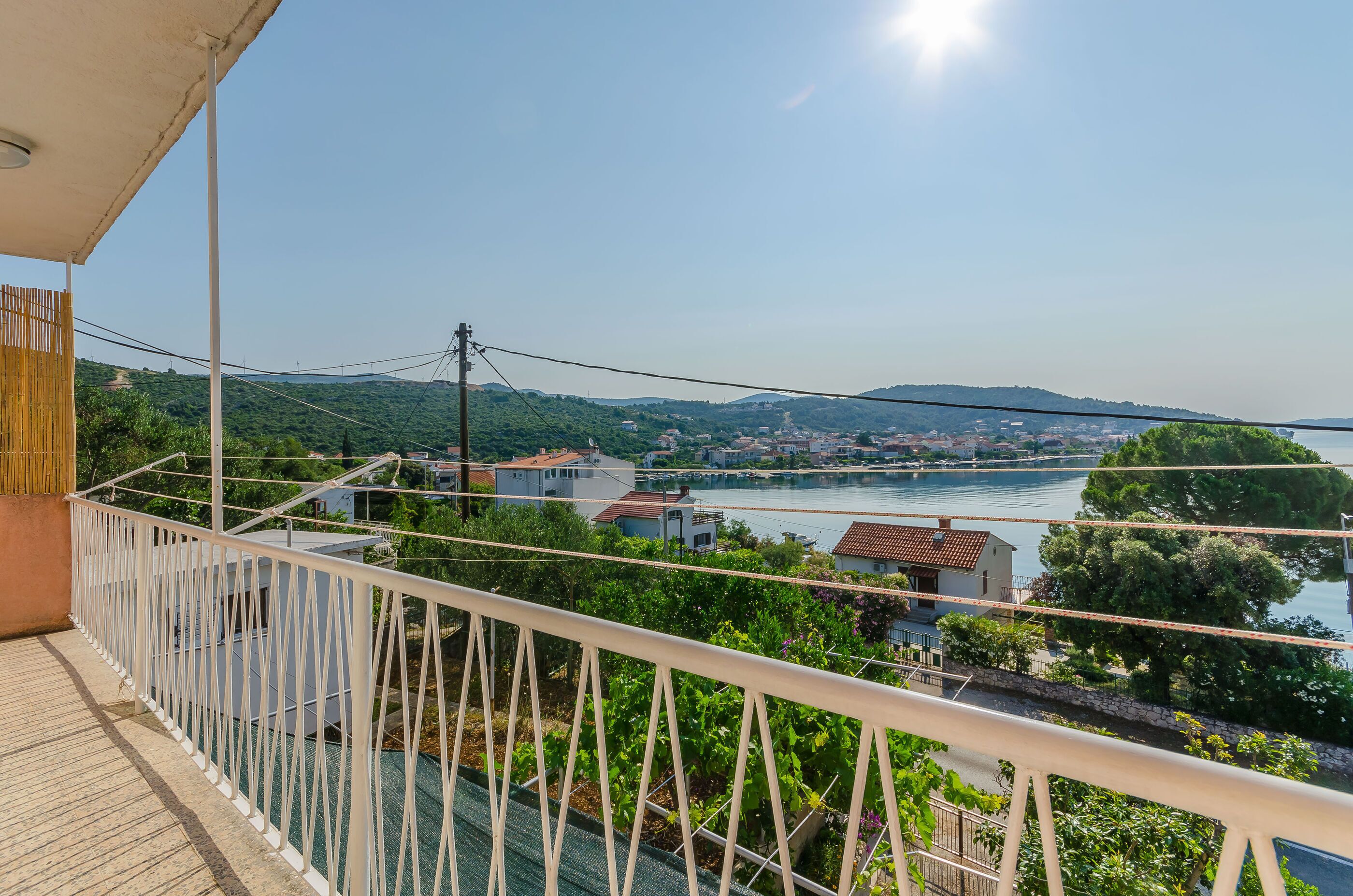 A balcony with a view of a river and hills.