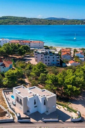 A coastal building complex with multiple structures, a swimming pool, and a view of the sea. - Villa Lemon Beach (Vodice)