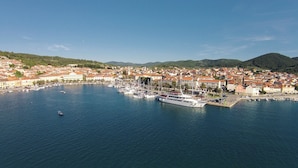A coastal town with a marina filled with boats, surrounded by red-roofed buildings and a church. - House Pelegrin (Vela Luka)