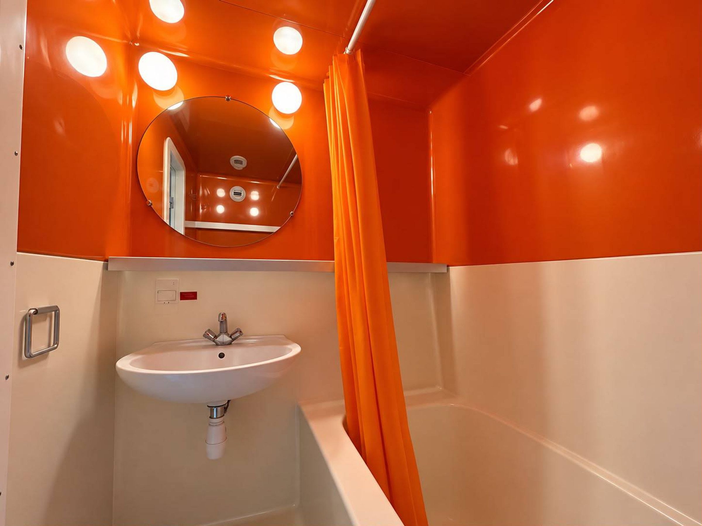 Un baño con lavamanos blanco, espejo y bañera.