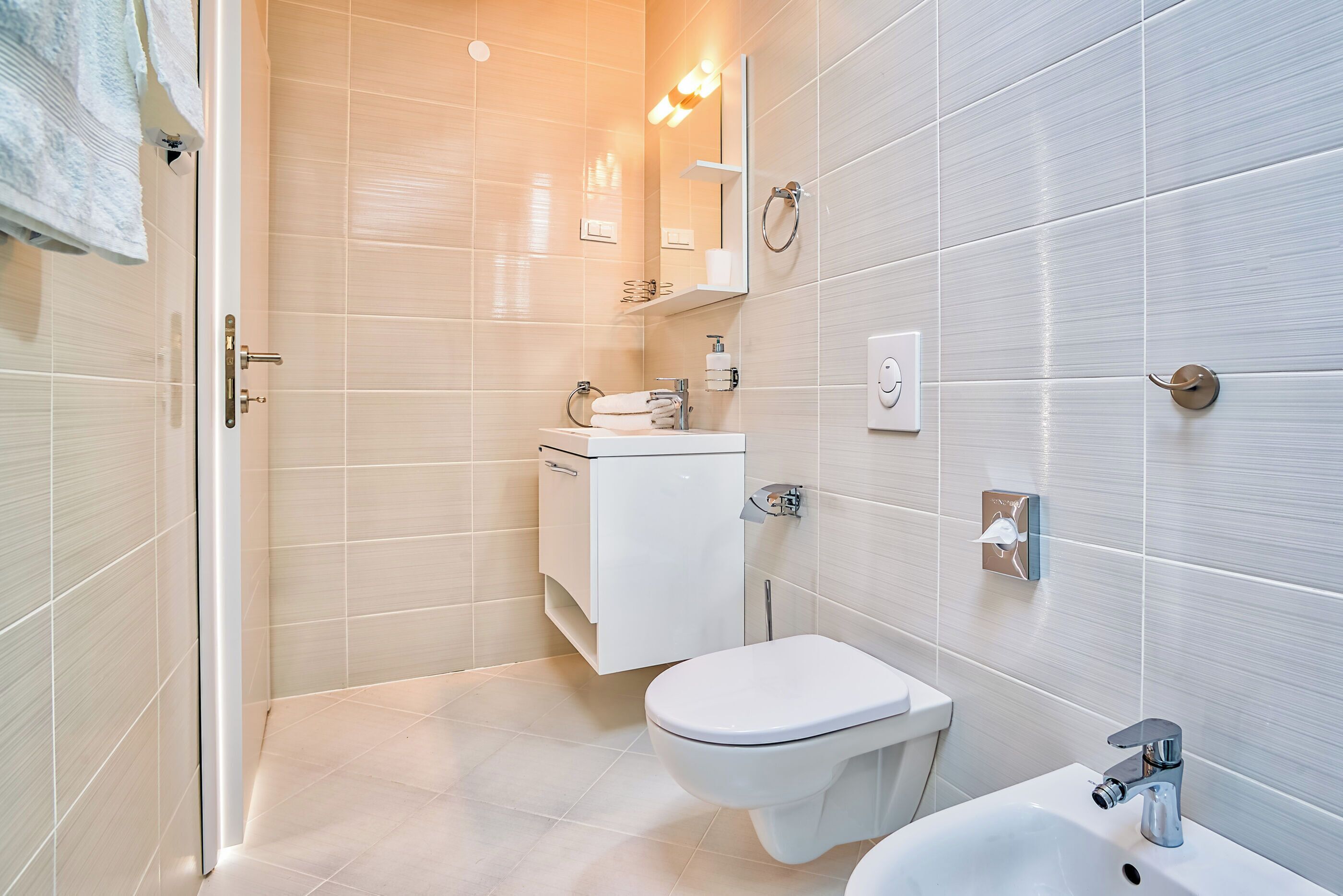 A modern bathroom with a toilet, sink, and shower area.