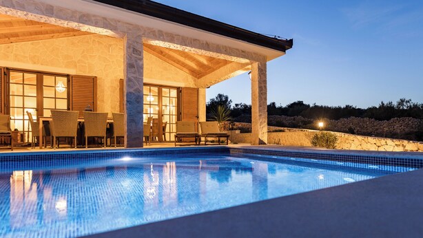 A swimming pool with a covered patio area, stone walls, and outdoor furniture. - Villa Maslina (Marina)